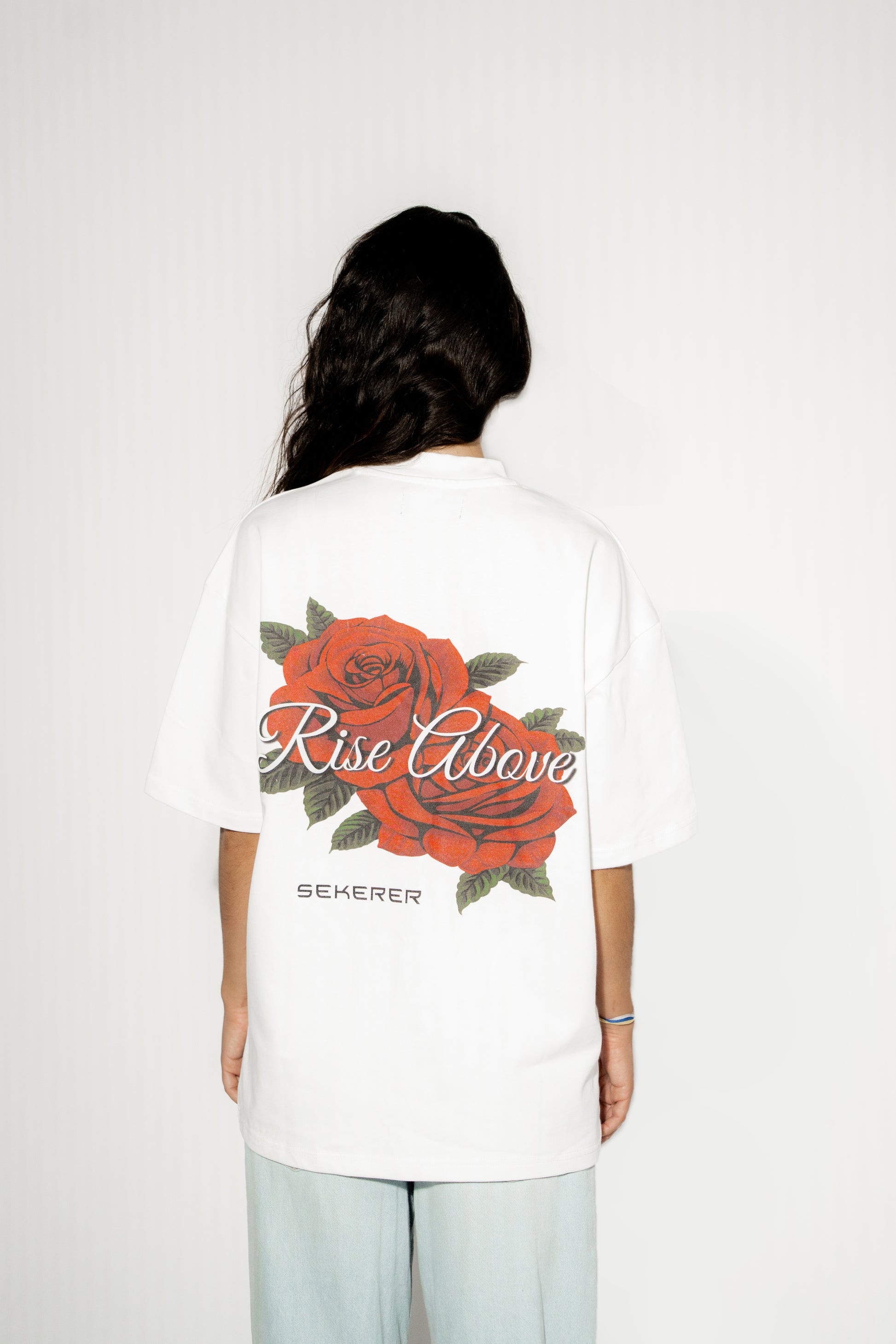 Female model wearing Ascend Rose oversized white t-shirt with rose back print